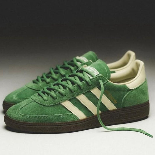 Green Adidas sneakers with white stripes on a gradient background