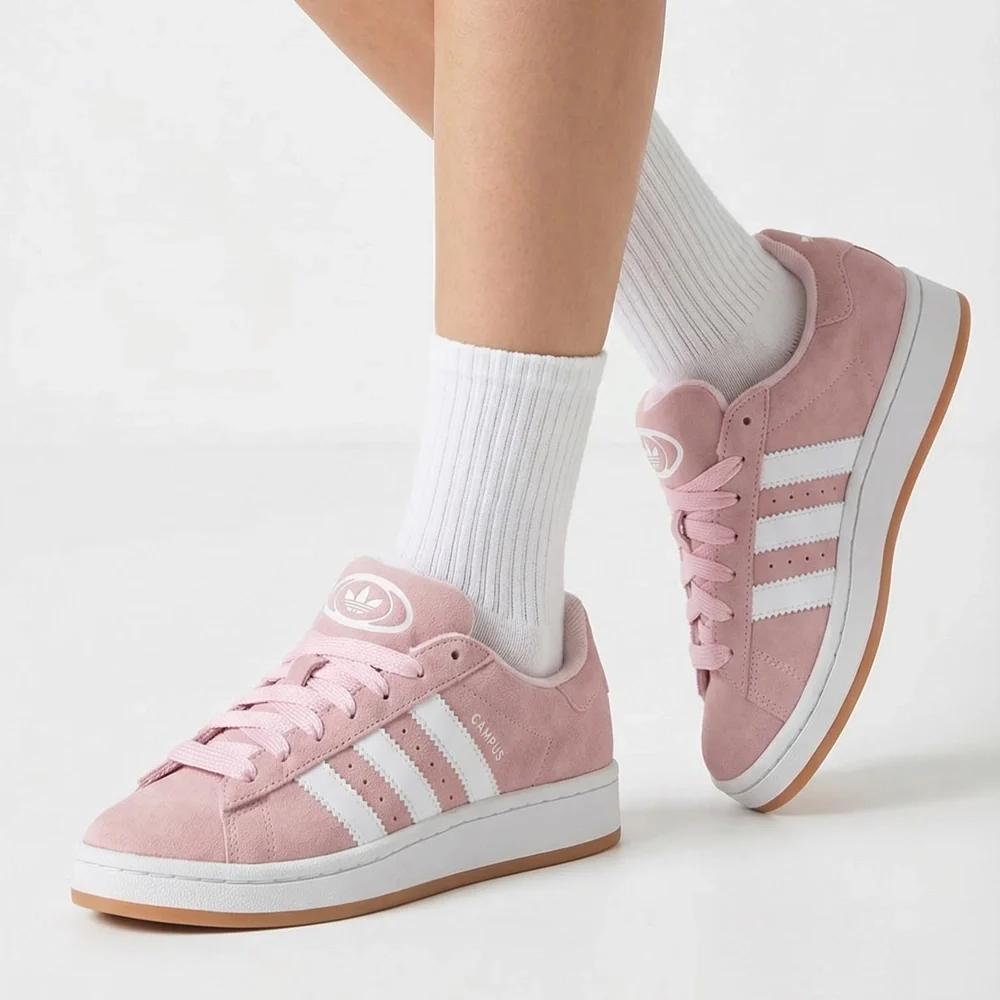 Pink Adidas campus sneakers with white stripes worn with white socks on a light background